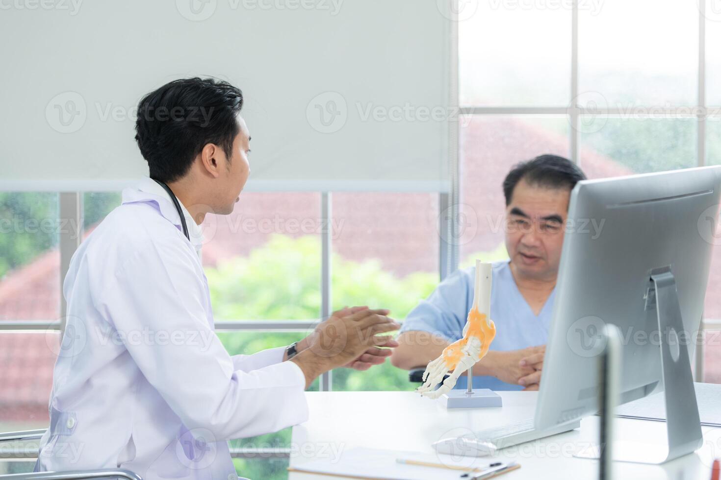 i de sjukhus kontor, en medicinsk förklarar handla om de fot ben och deras behandling till en patient foto