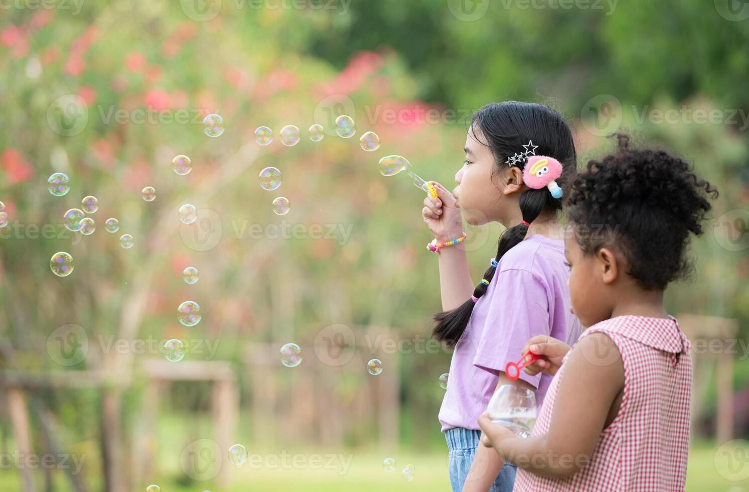 flickor i de parkera med blåser luft bubbla, omgiven förbi grönska och natur foto