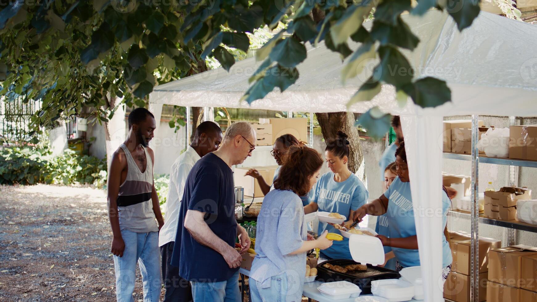 volontärer tjänande fri mat till de behövande på ett utomhus- händelse. detta ideellt organisation erbjudanden humanitär hjälpa och fostrar gemenskap, portion de hungrig och hemlös. antenn, handhållen. foto