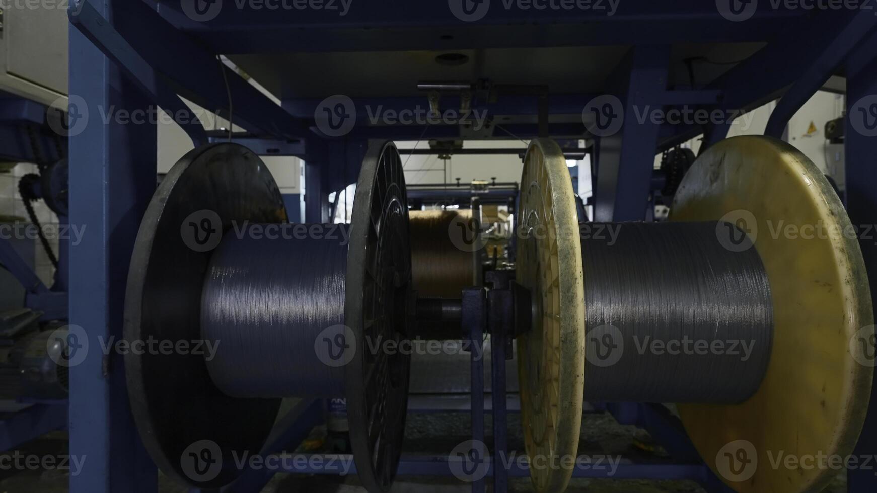 roterande spolar i industriell företag. kreativ. bearbeta av plast legering och lindning av polymer stavar. kemisk verkstad av industriell växt foto