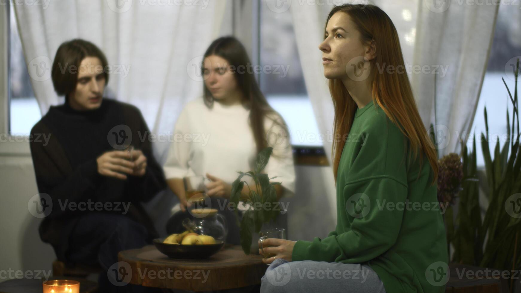 studenter prata och koppla av i mysigt Kafé. media. skön ung kvinna är dricka te på bakgrund av talande par. studenter koppla av och dryck te i högskola Kafé foto