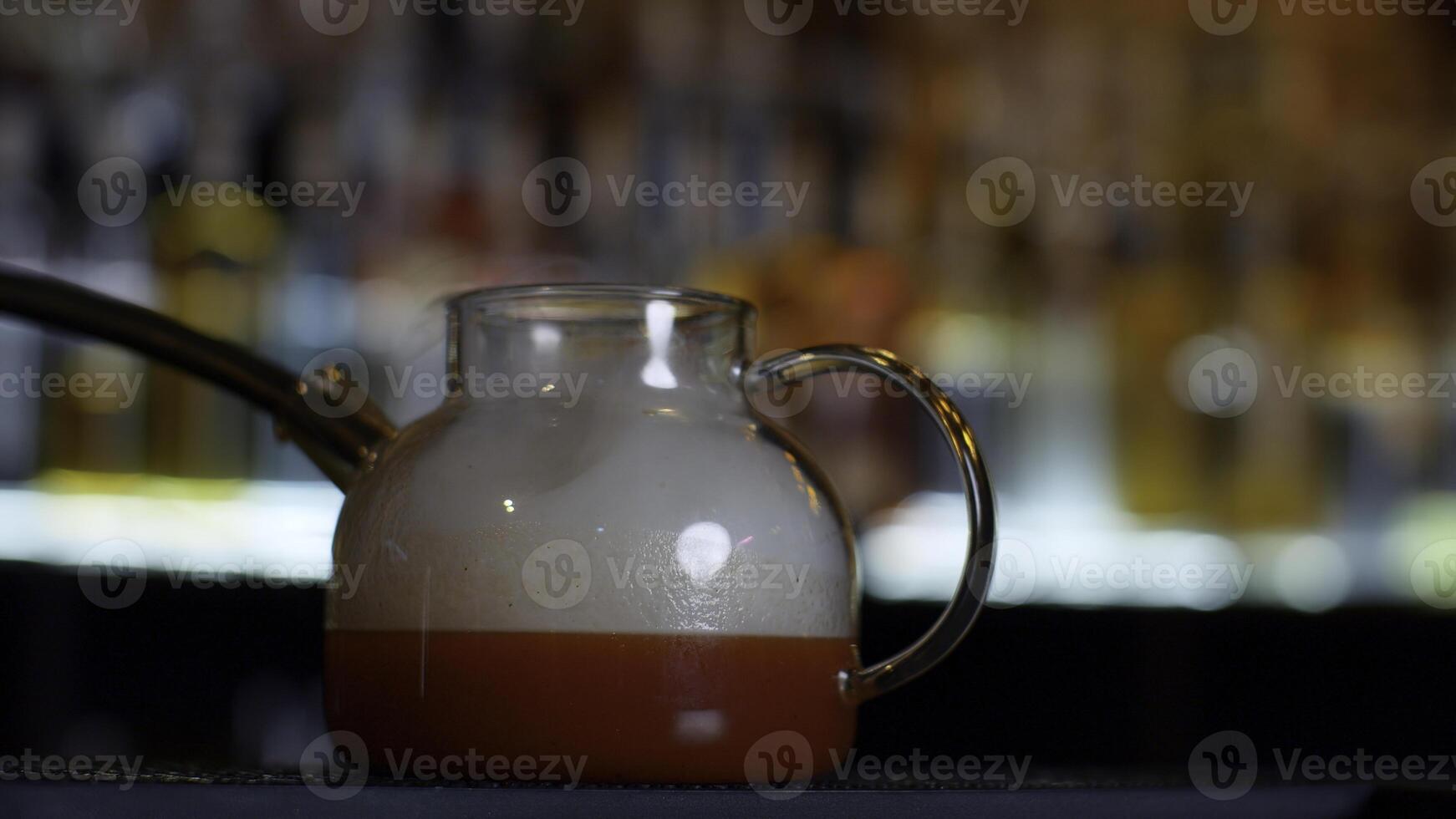 stänga upp av framställning röd frukt te på en bar eller restaurang. media. bartender tillsats rök in i de te pott genom de rör. foto