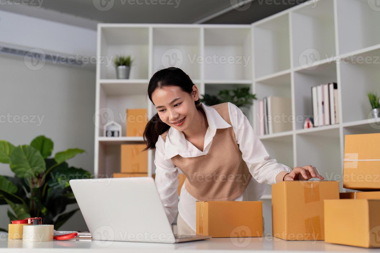 ung kvinna arbetssätt uppkopplad e-handel handla på henne affär. ung kvinna säljare förbereda paket låda av produkt för leverera till kund. uppkopplad försäljning, e-handel. försäljning Produkter uppkopplad foto