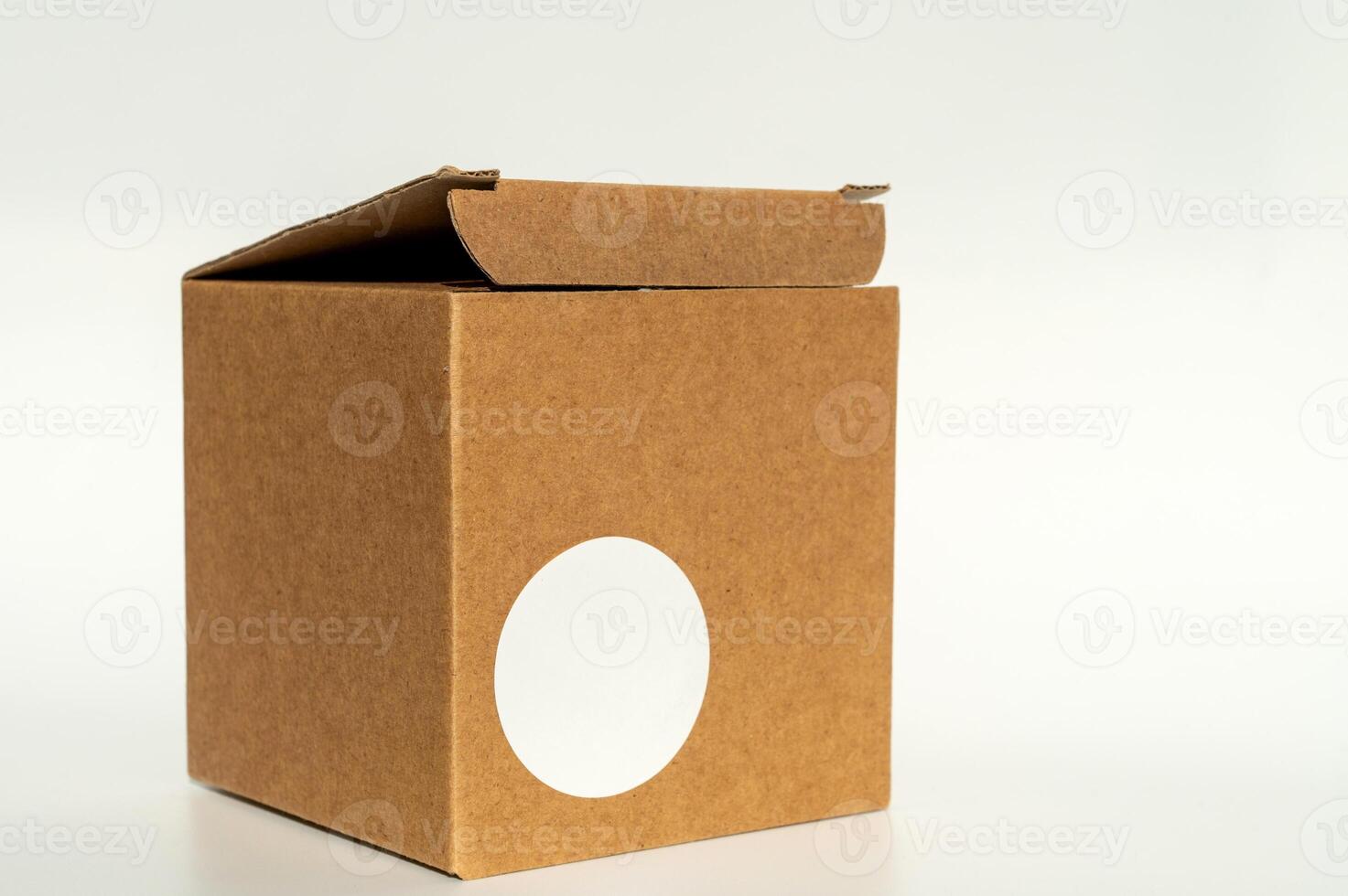 brun kartong låda med cirkulär vit klistermärke på en neutral bakgrund. foto
