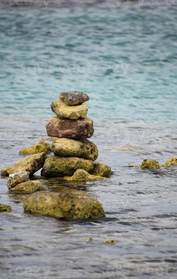 grön stenar staplade och balanserad i grund vatten foto