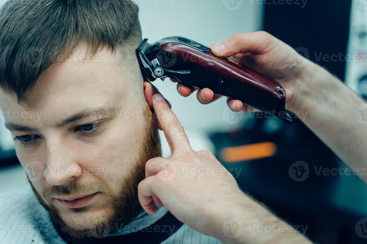 manlig frisyr med elektrisk rakapparat. barberare gör frisyr för klient på de barberare affär förbi använder sig av hårtrimmer. man frisering med elektrisk rakapparat. foto