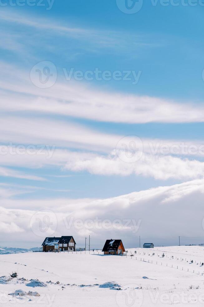 färgrik by hus i en snöig berg dal mot de bakgrund av moln foto