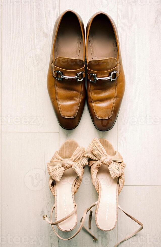 brud och brudgum skor stå motsatt varje Övrig på en ljus laminera golv. topp se foto
