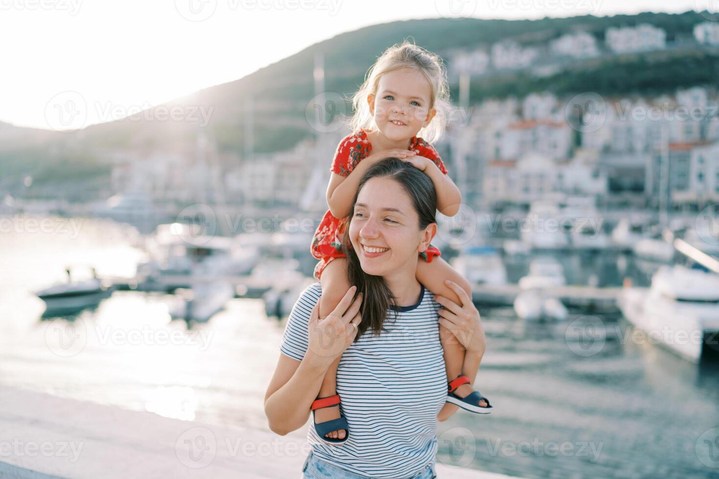 glad mor och dotter njuter en solig dag på de marina foto