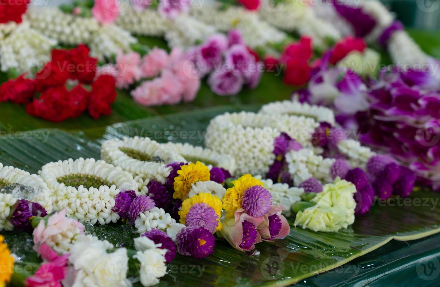 vacker thailändsk traditionell blomkrans gjord av många typer av blommor till salu på färskmarknaden foto