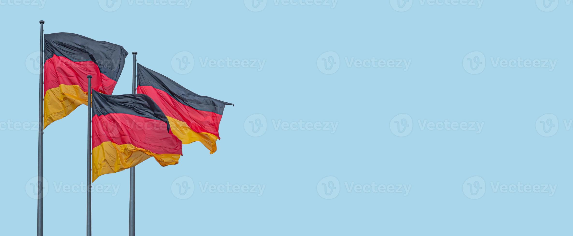 banderoll med tre nationella svarta röda gula flaggor från Tyskland i vind och på blå himmel bakgrund med kopia utrymme, detaljer, närbild. begreppet nationalitet, medborgarskap och patriotism. foto
