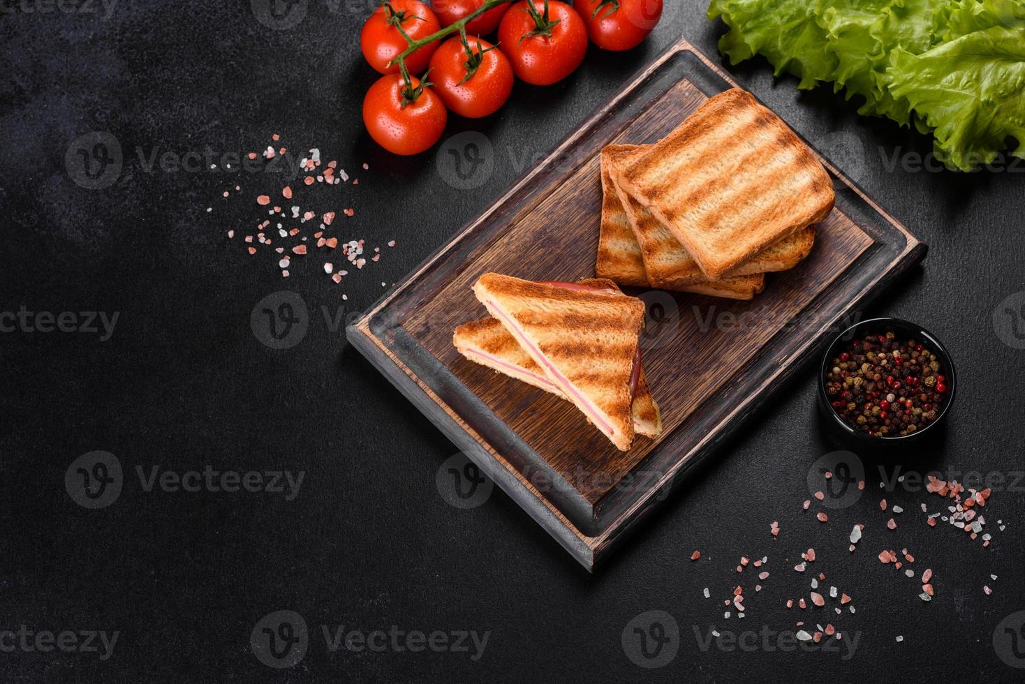 smörgås med skinka, ost, tomater, sallad och rostat bröd foto