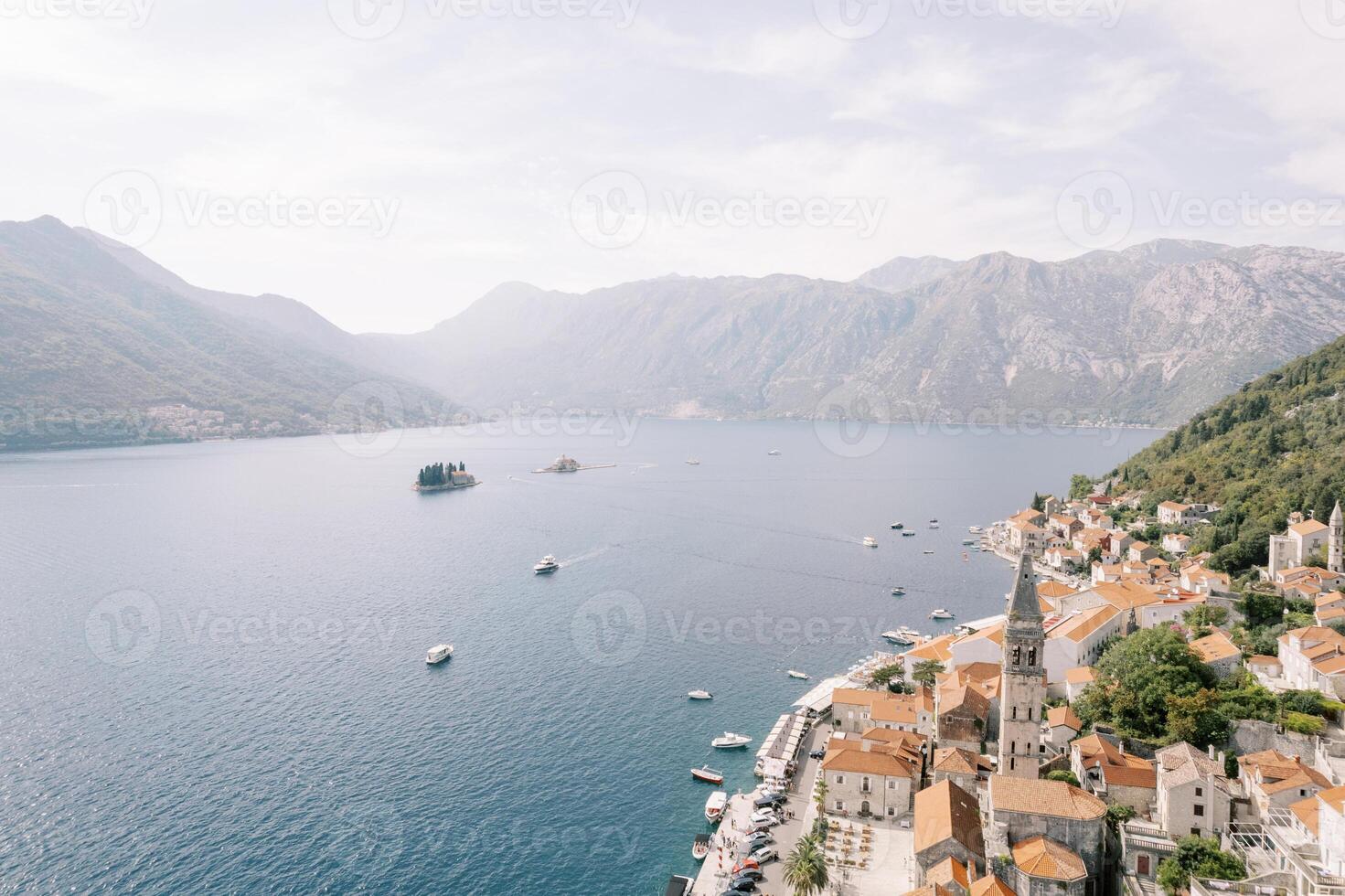 Strand av perast med en hög klocka torn bland gammal hus utsikt de öar av de bukt av kotor. montenegro. Drönare foto