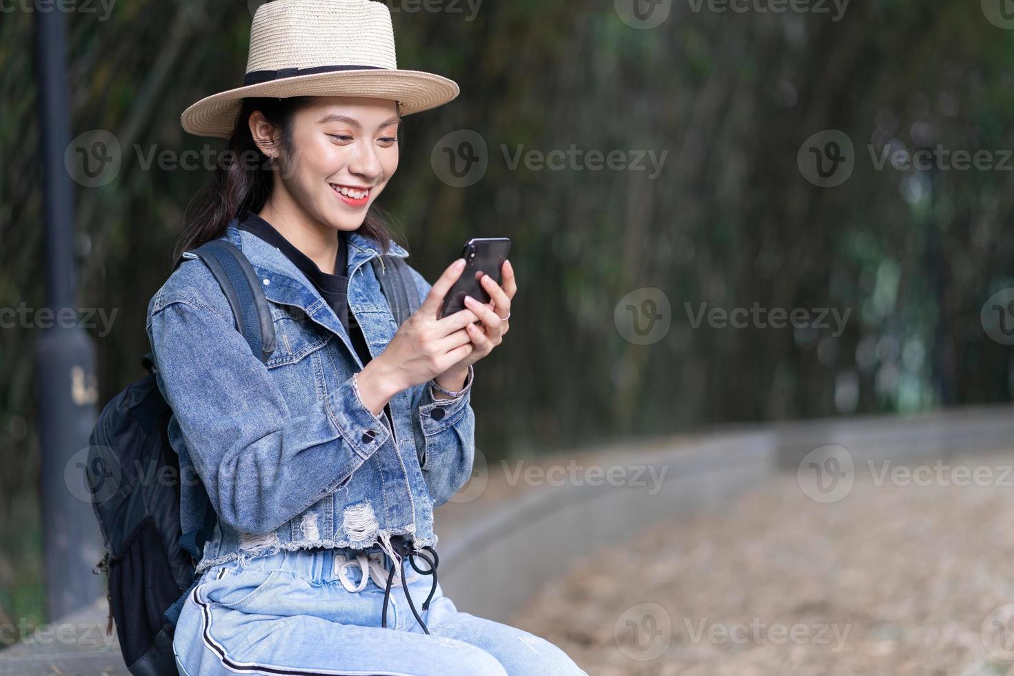 ung asiatisk kvinna utforskar skogen på semester foto