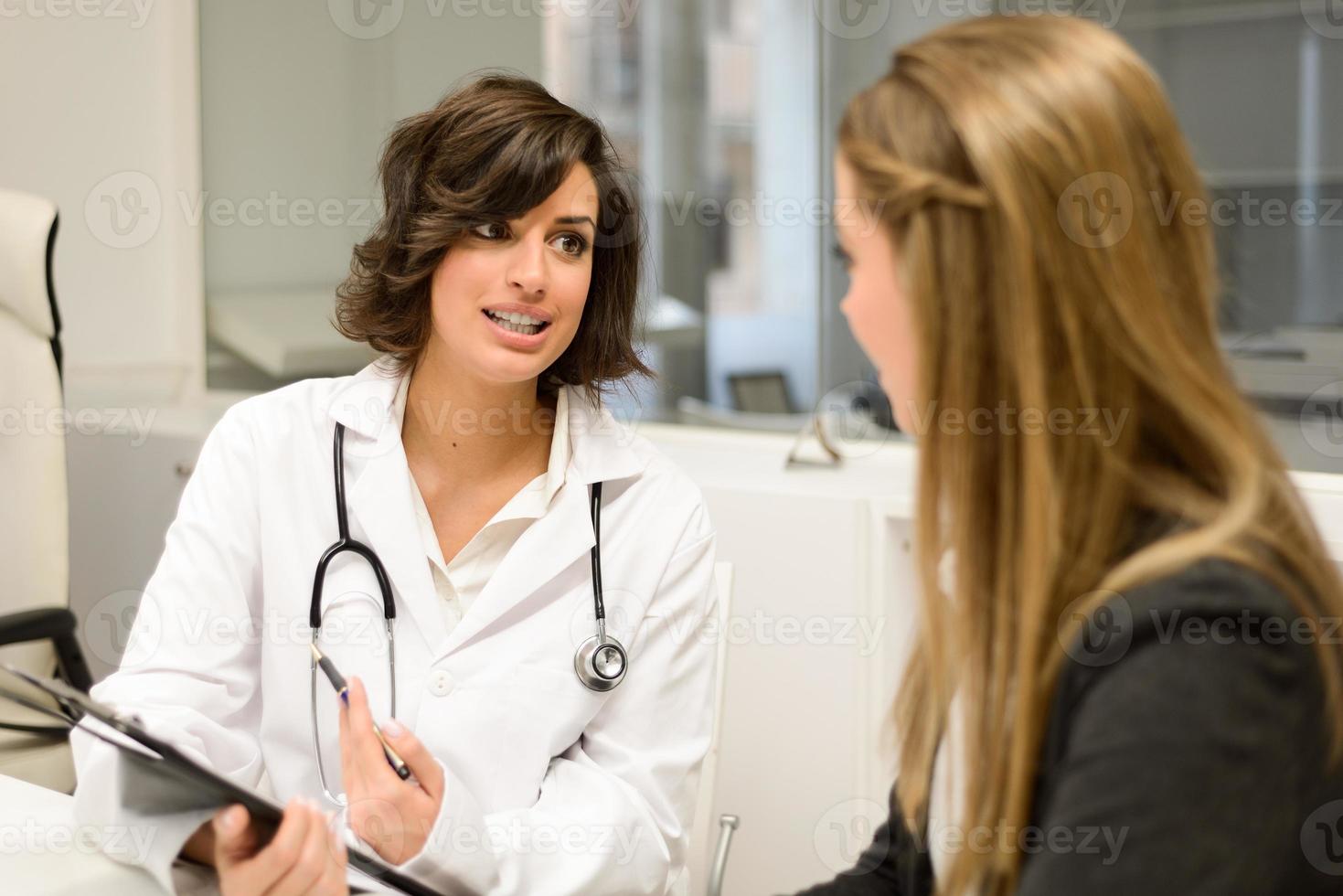 läkare som förklarar diagnosen för sin kvinnliga patient foto