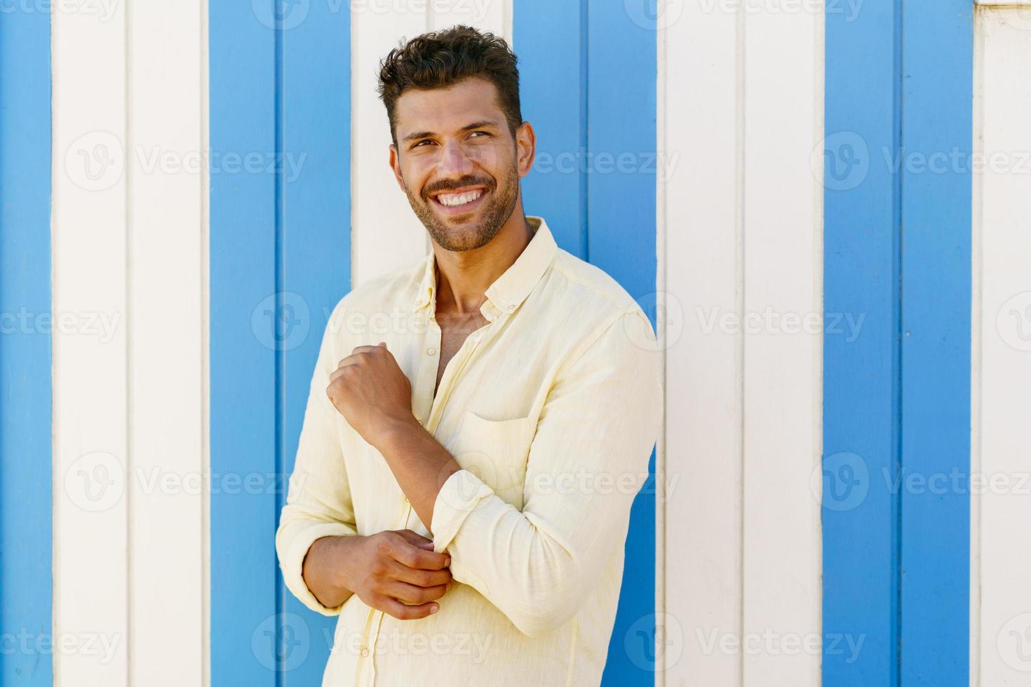 ung man, fotomodell, poserar framför en strandbås. foto
