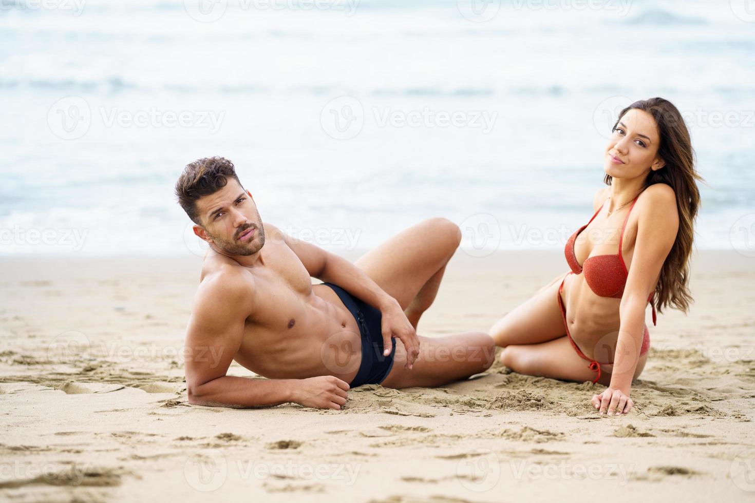 ungt par sitter tillsammans på sanden på stranden foto