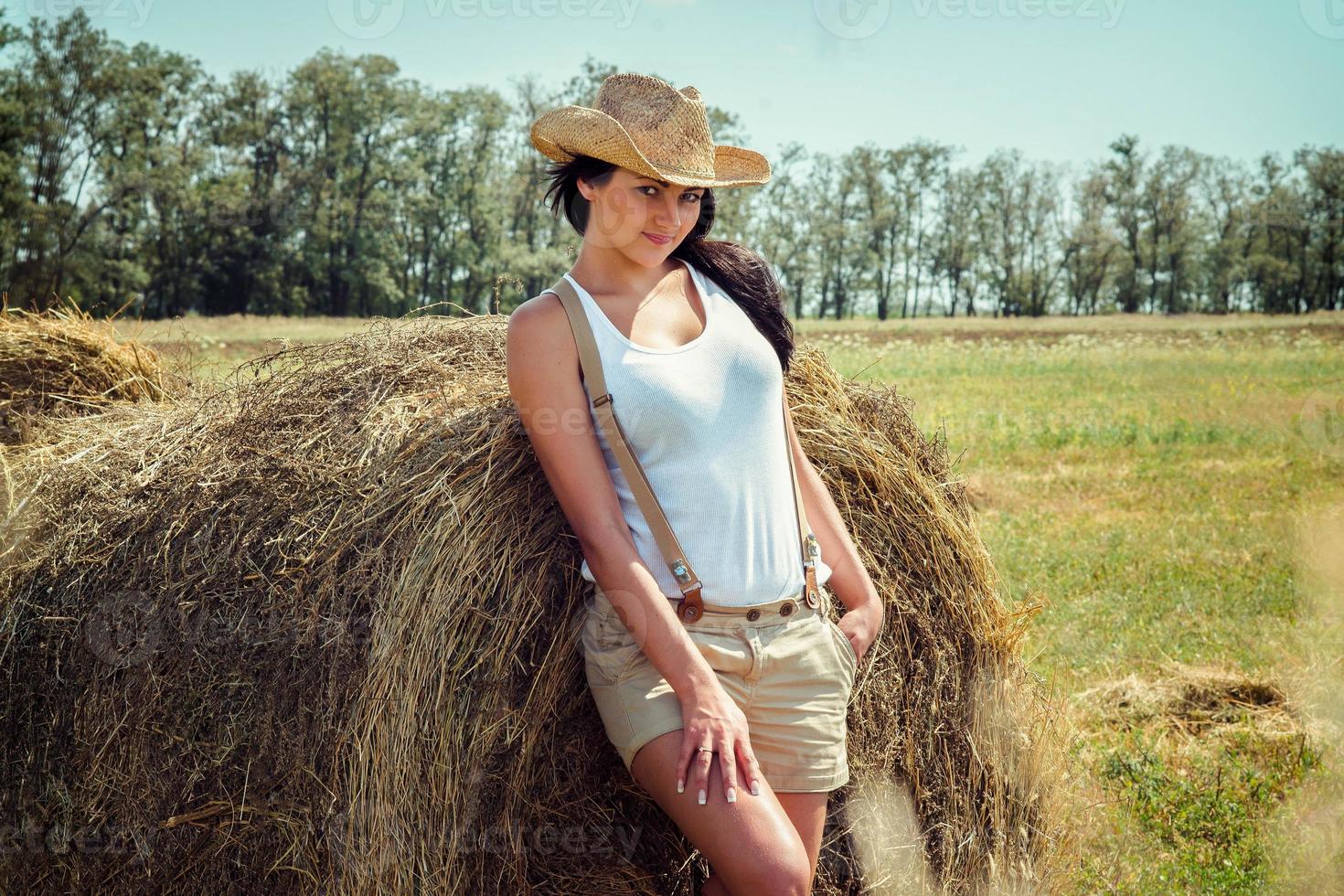 flicka med svart hår i beige ullrockar står nära höstackarna foto