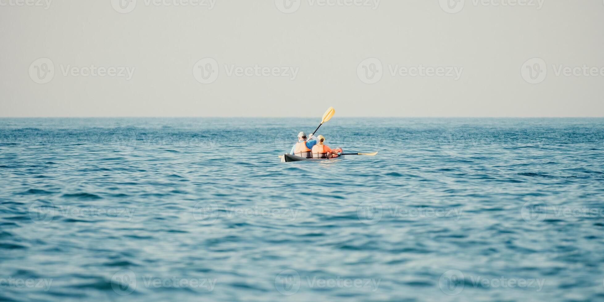 Lycklig par kajaker i ett uppblåsbar kajak på de hav på solnedgång. par kanotpaddling i de hav nära de ö med berg. människor Kajakpaddling i liv jackor segla. tillbaka se foto