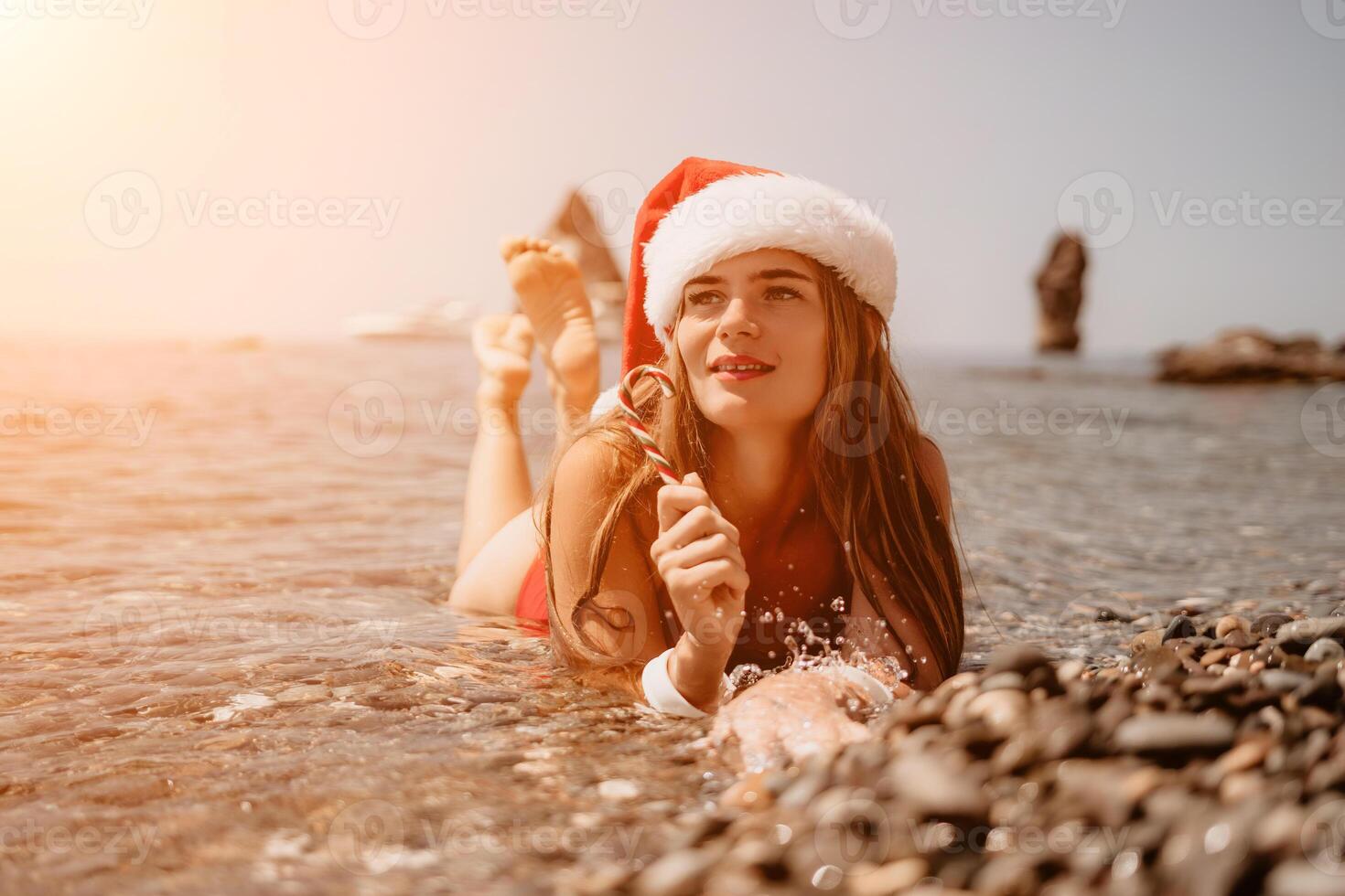 kvinna resa hav. Lycklig turist njut av tar bild på de strand för minnen. kvinna resande i santa hatt utseende på kamera på de hav bukt, delning resa äventyr resa foto