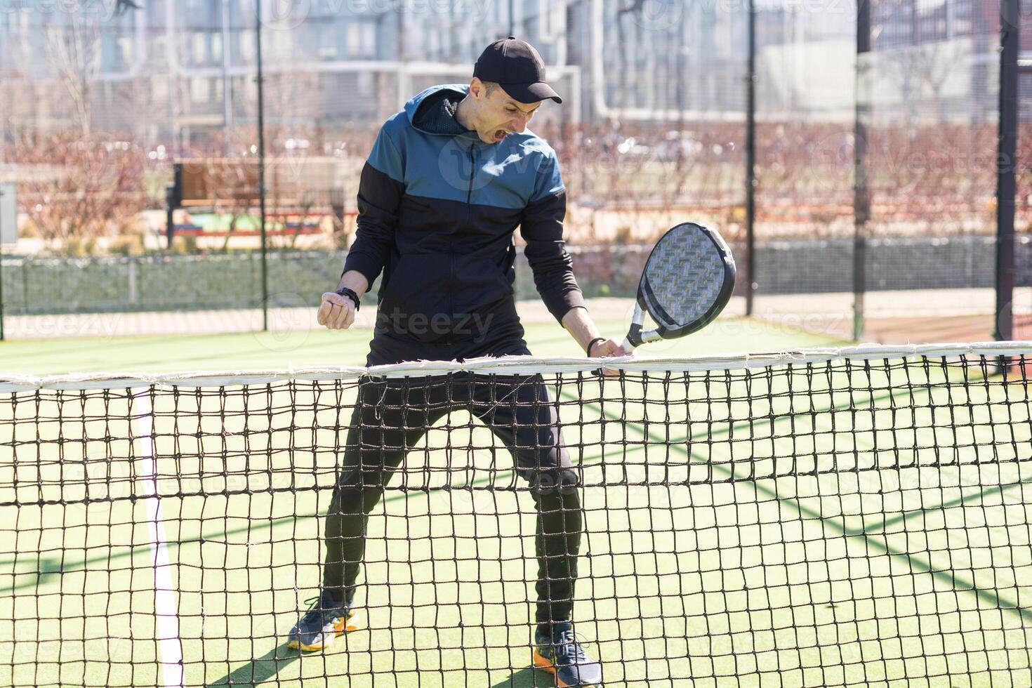 porträtt av en europeisk man padel tennis spelare spelar på de utomhus- domstol foto