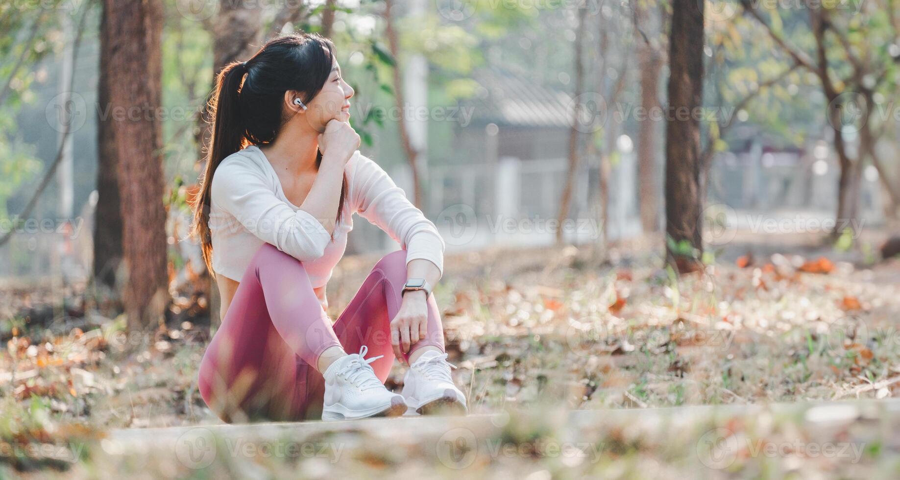en ung kvinna åtnjuter en fredlig ögonblick Sammanträde utomhus, klädd i träna kläder och förlorat i trodde. foto