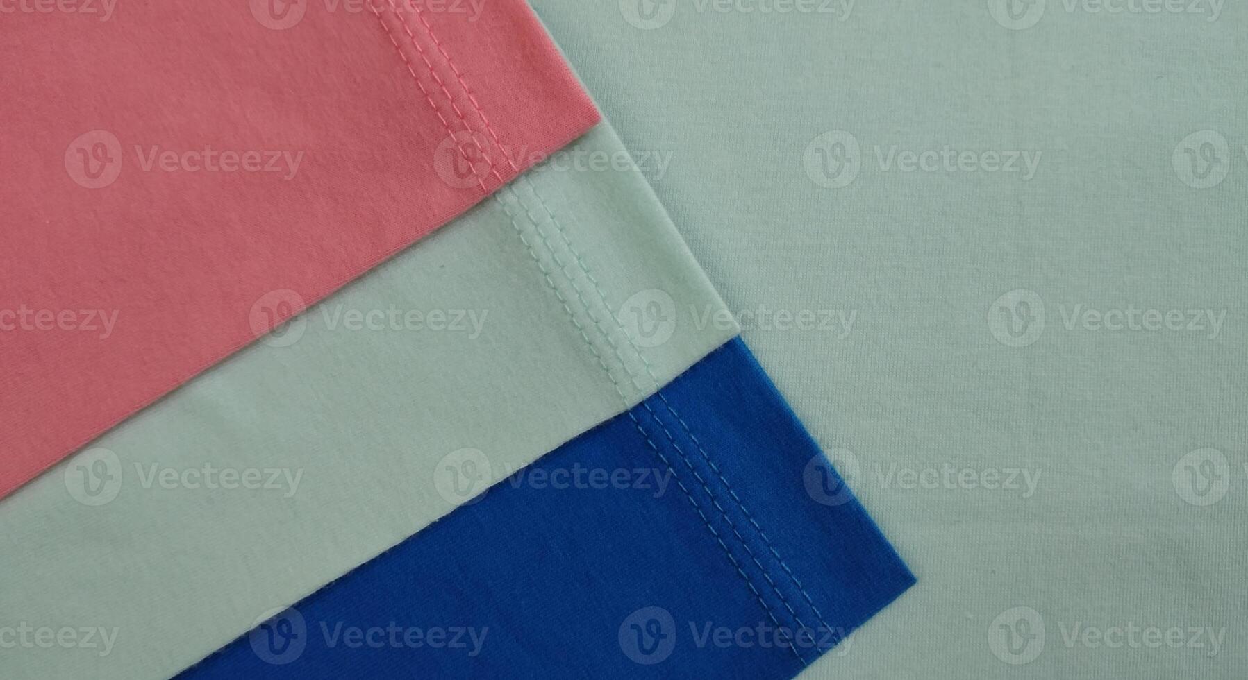 tyg prover i annorlunda nyanser av blå och rosa, närbild på grön bakgrund foto