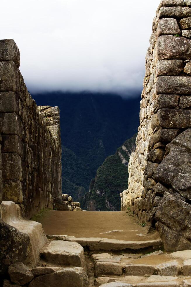 machu picchu, peru, 2015 - inka sten väggar med bergen och mulen himmel foto
