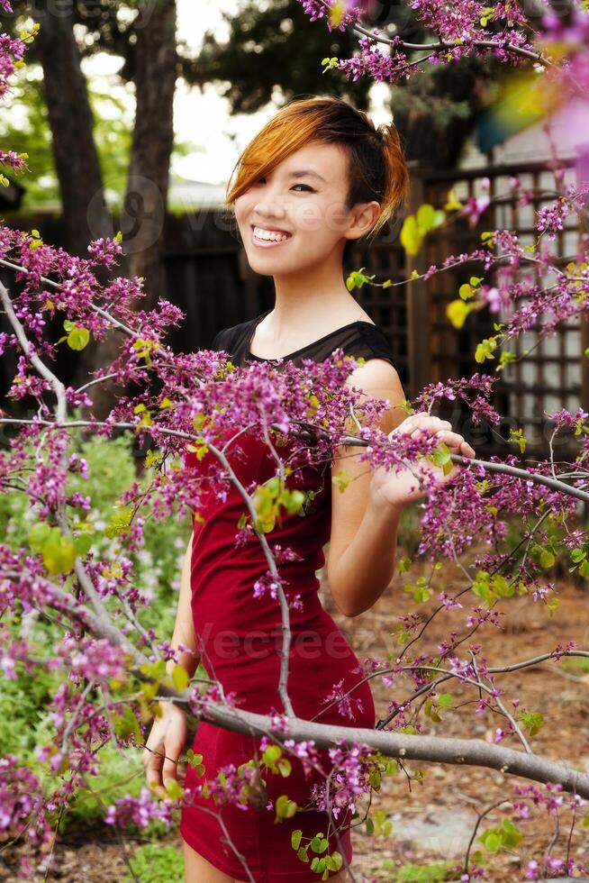 leende attraktiv asiatisk amerikan kvinna stående utomhus foto