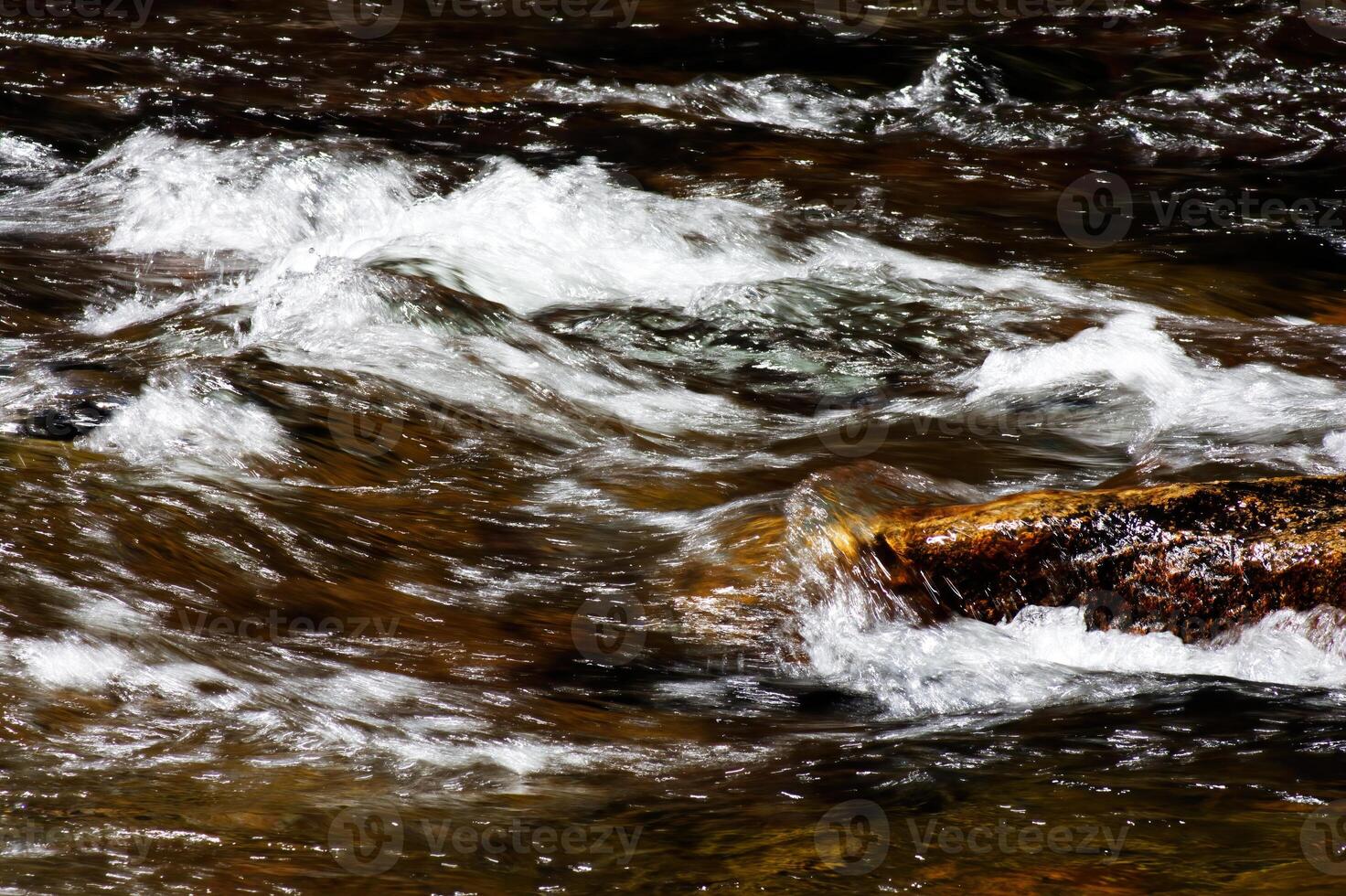 vit flod vatten fors strömmande över stenar foto