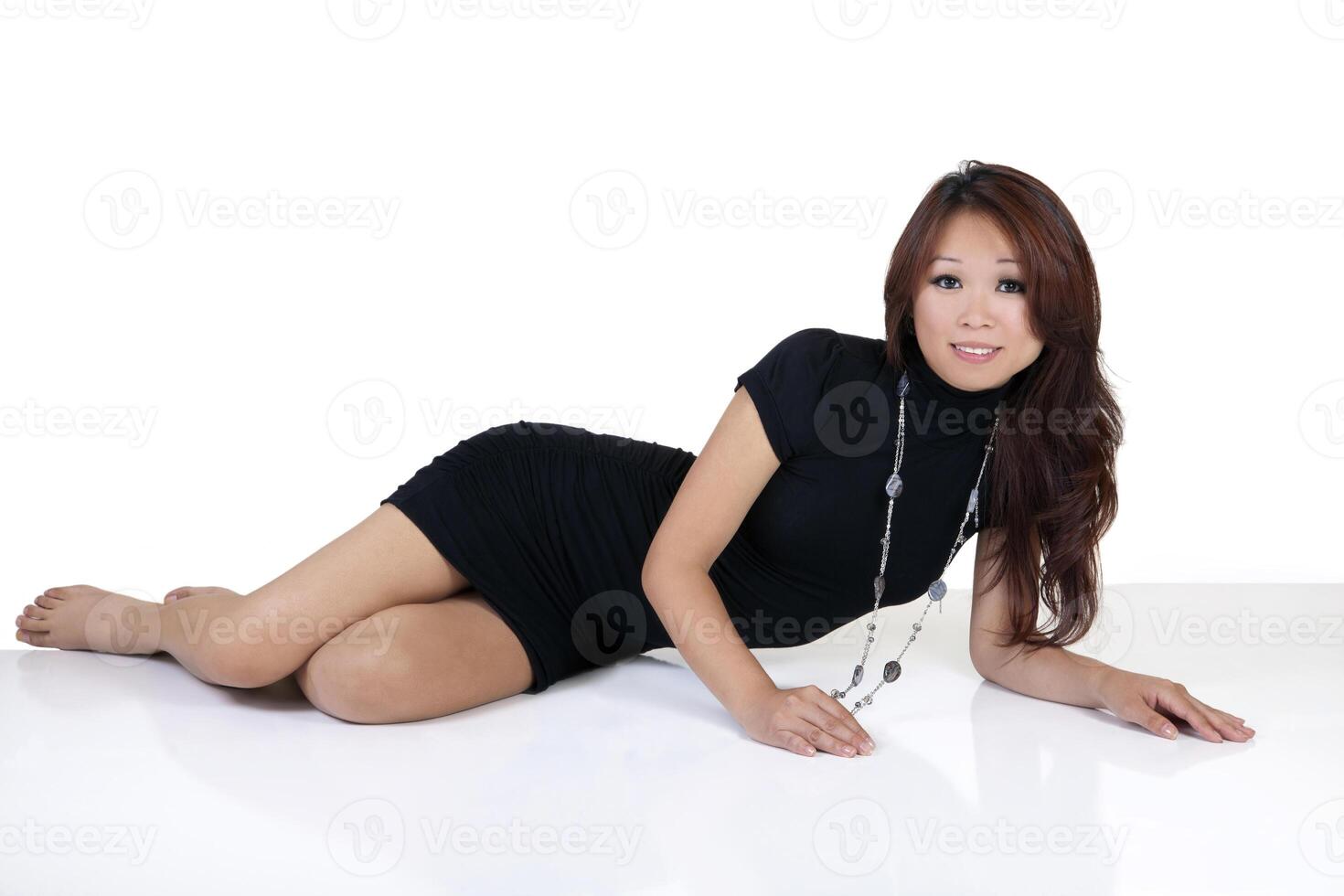 ung asiatisk amerikan kvinna liggande vit golv foto