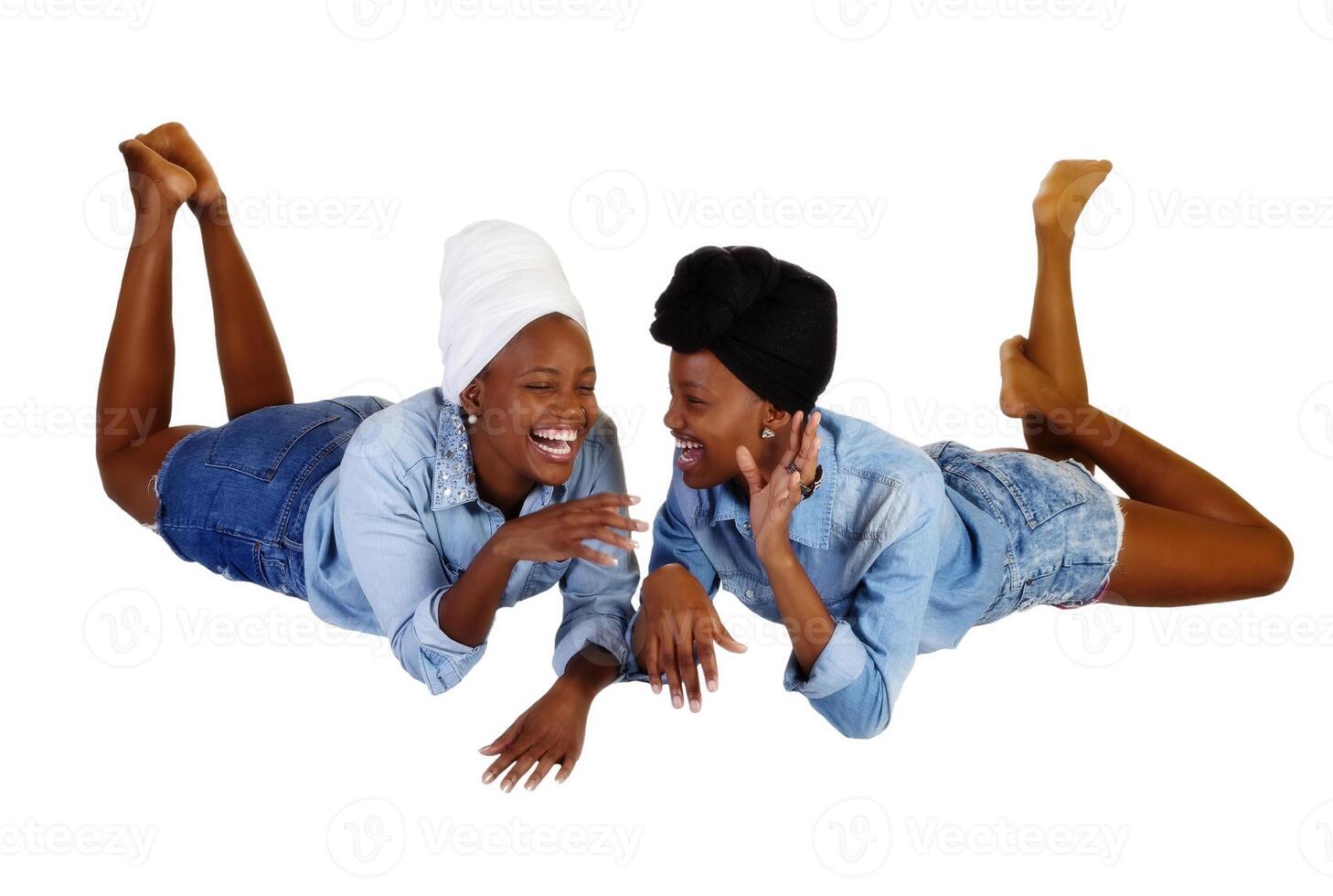 två svart systrar liggande öppen mun skratt foto