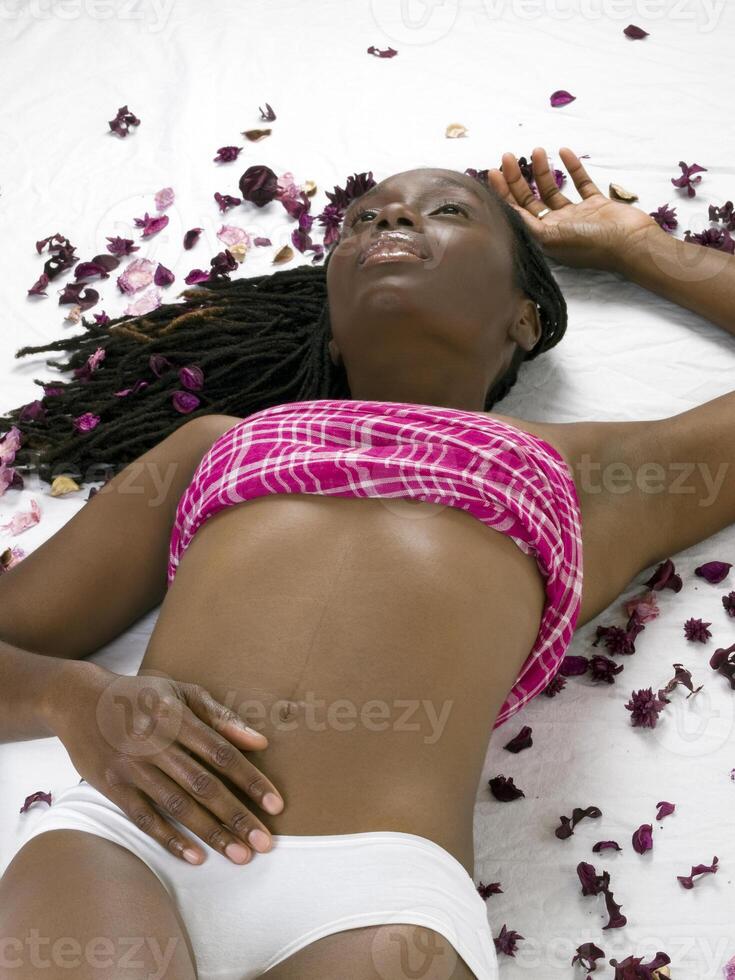 ung svart kvinna i vit trosor på golv foto