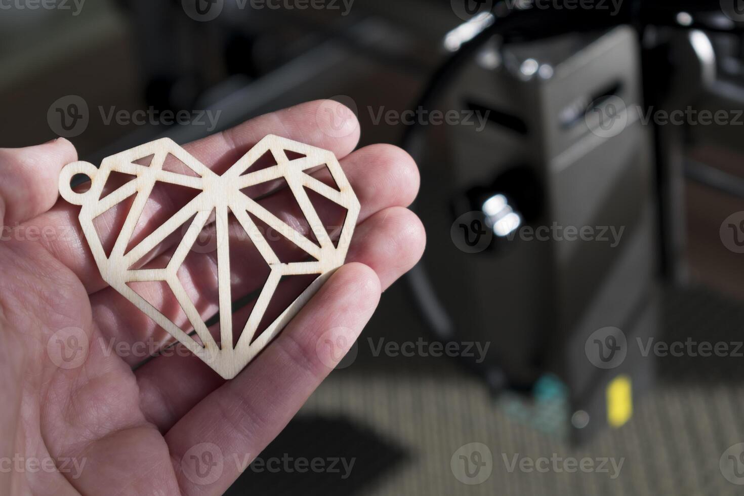 laser gravyr och skärande, hand innehav ett exempel av en skära ut trä- hjärta foto