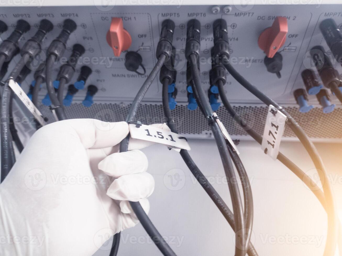 en teknik kontroll sträng kabel- rader i inverterare sol- panel.the hand håll en sträng kabel- för kolla upp och reparera. inverterare service begrepp för teknologi bakgrund. foto