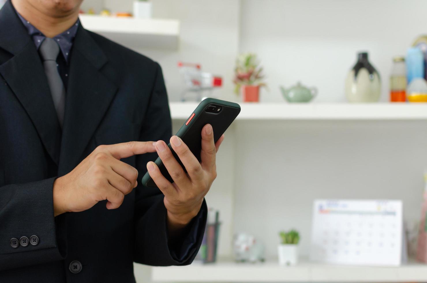 affärsman håller mobiltelefon för affärskommunikation eller marknadsföring online. foto