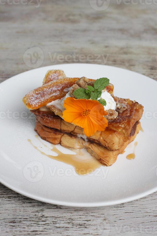 hasselnöt karamaliserad banan brioche fench rostat bröd eras i maträtt isolerat på trä- bakgrund topp se av frukost foto