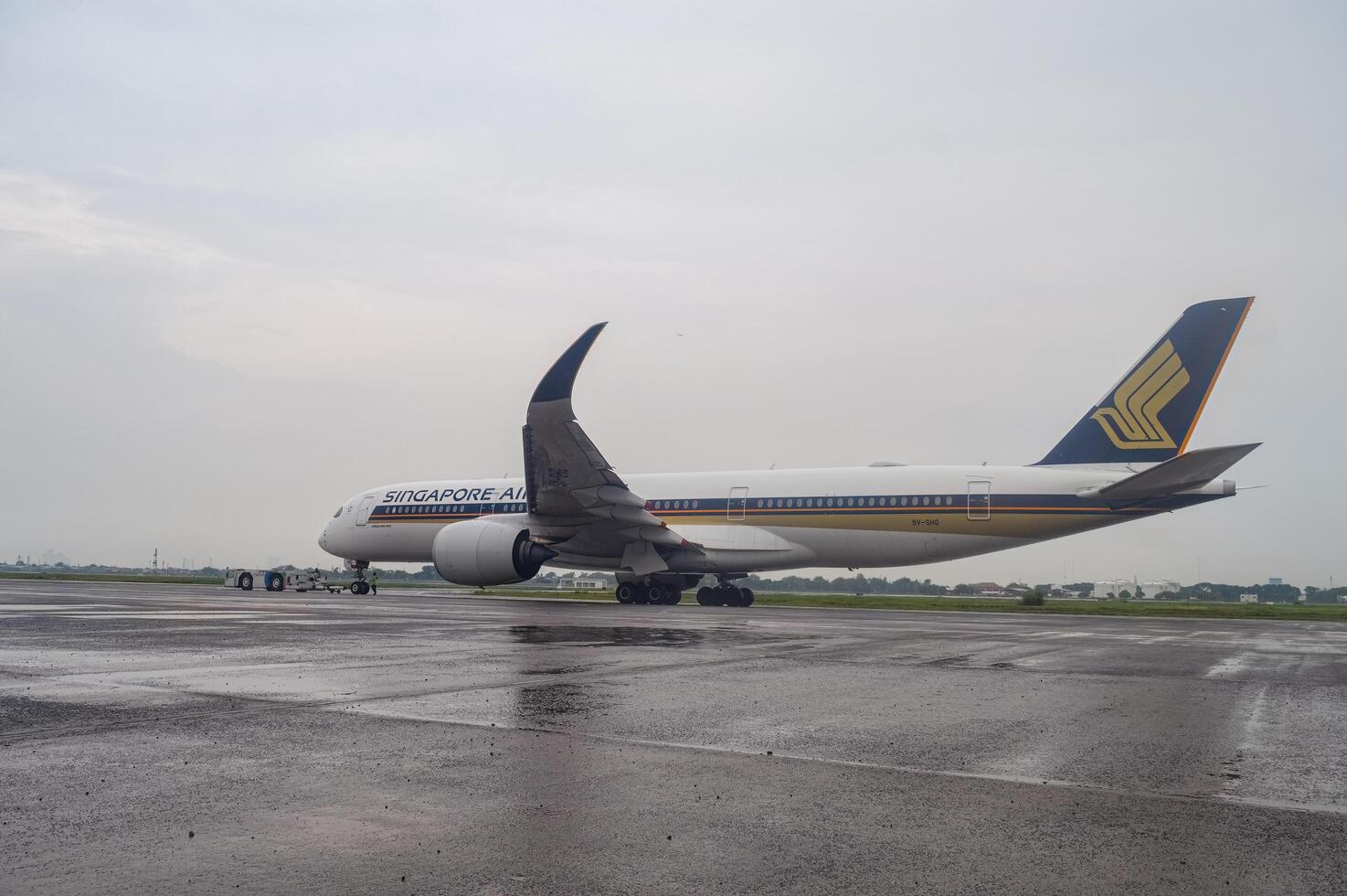 ett flygbuss a350-941 bred kropp flygplan som tillhör till singapore flygbolag är varelse bogserad använder sig av en trycka tillbaka bil på de förkläde av juanda internationell flygplats, surabaya i Sidoarjo, Indonesien, 6 januari 2024 foto