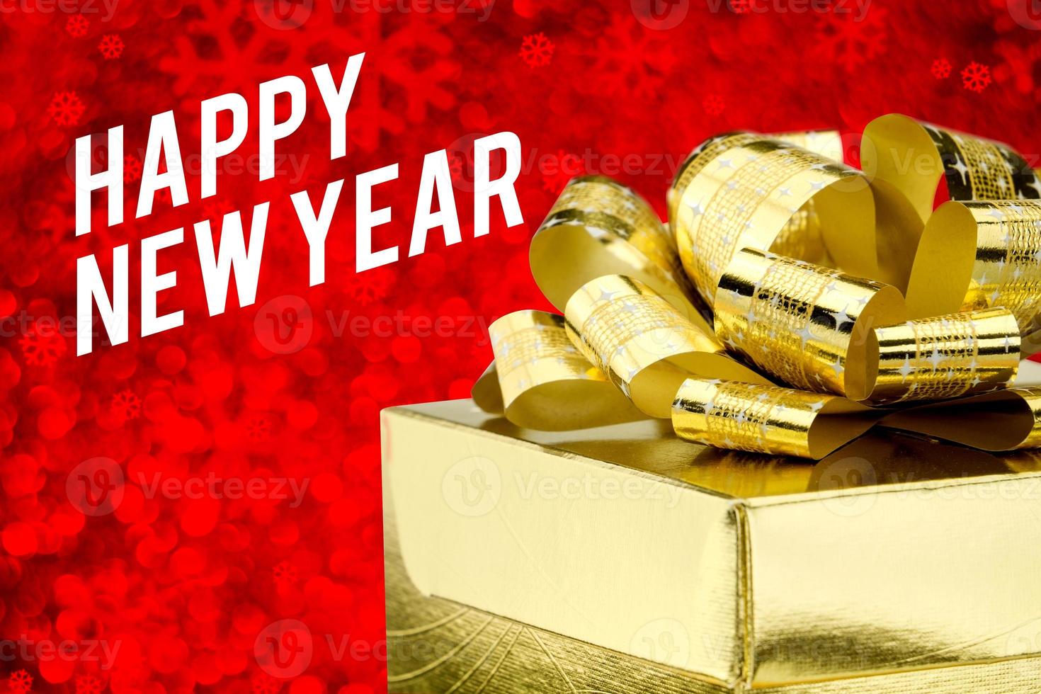 gott nytt år ord med gyllene presentförpackning med band och färgglada konfetti på oskärpa rött foto