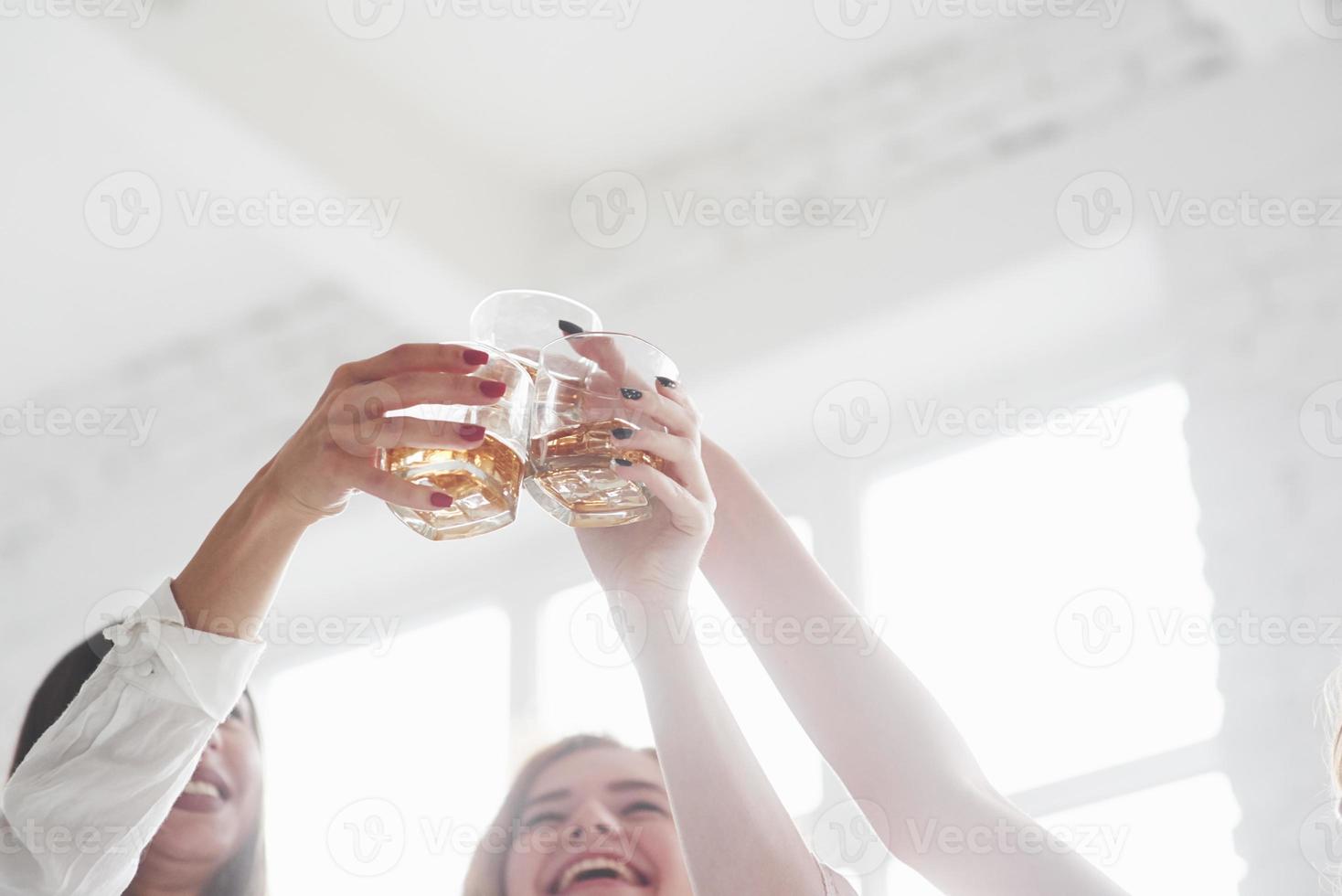 whiskyglas i luften. flickor som festar med alkohol foto