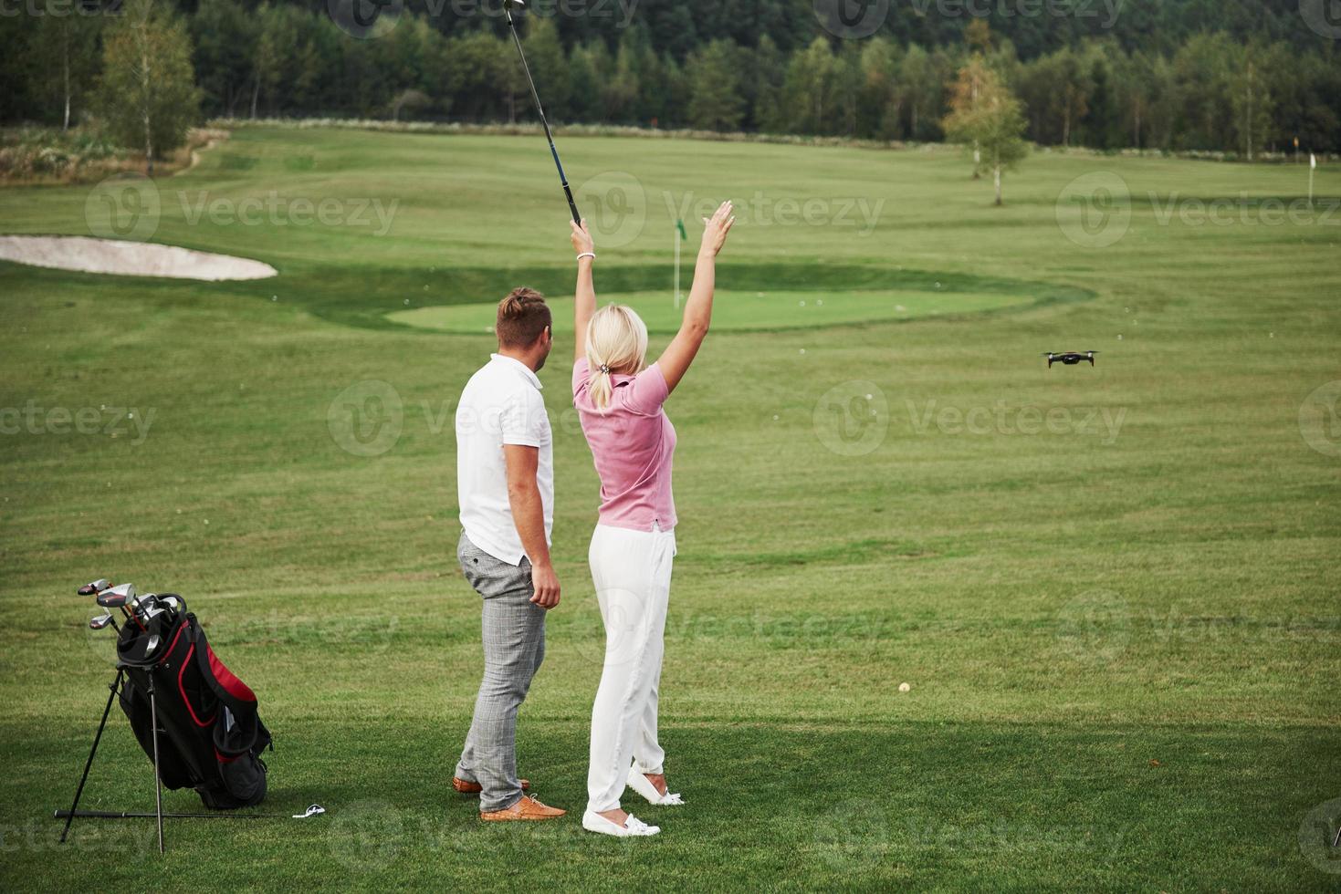 grupp snygga vänner på golfbanan lär sig spela ett nytt spel foto