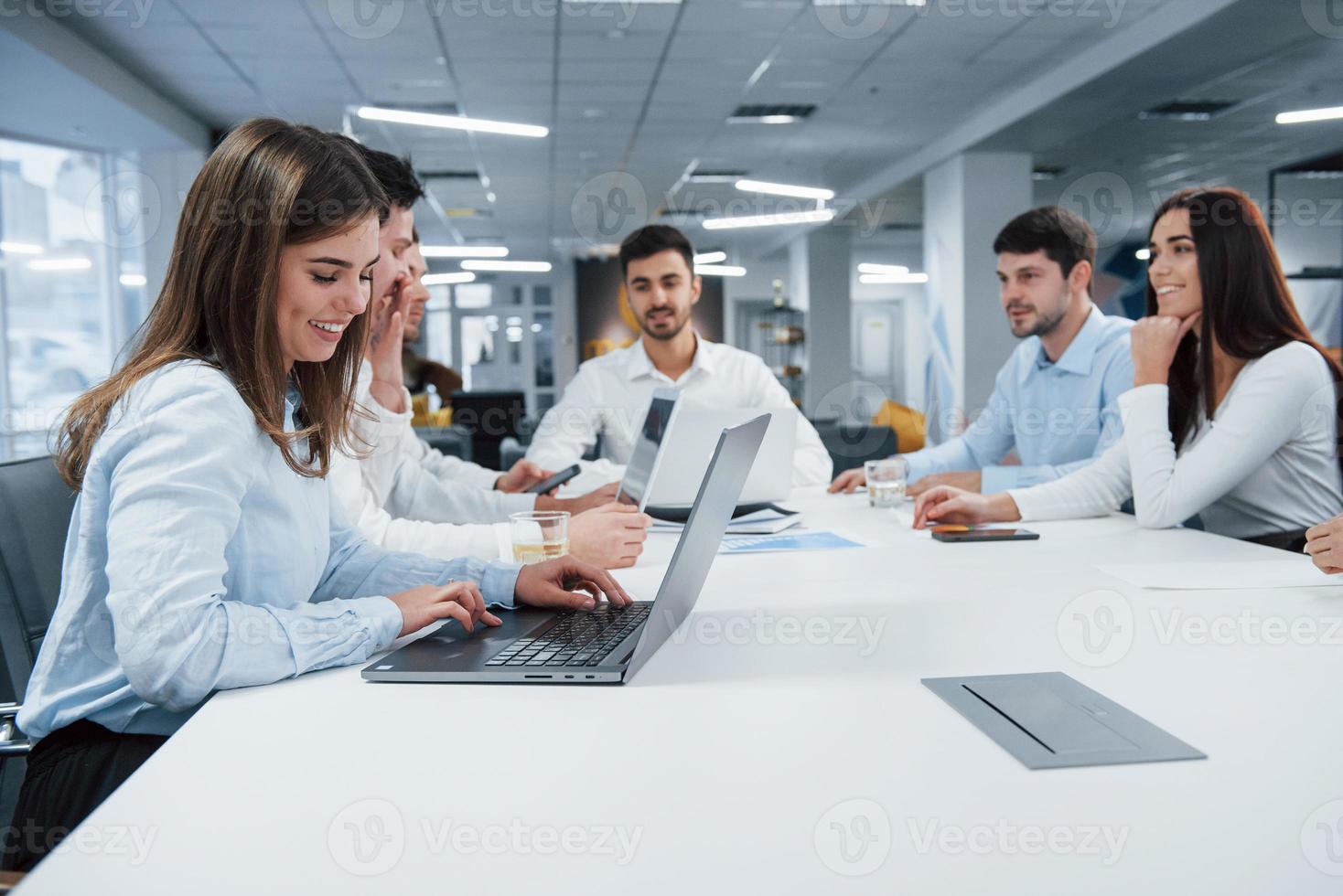 de älskar verkligen sitt jobb. grupp unga frilansare på kontoret pratar och ler foto