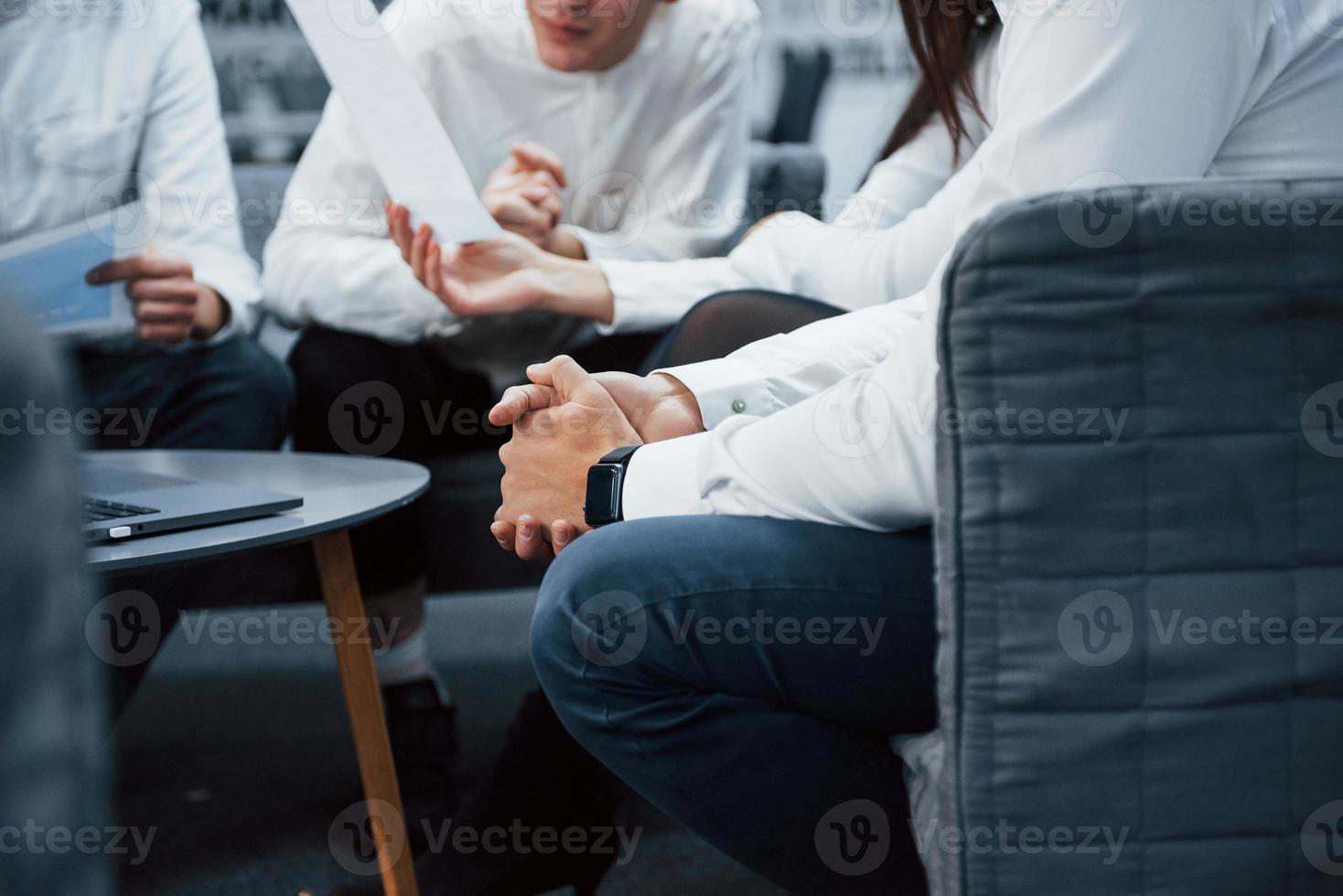 närbild av mannens händer. människor sitter på kontoret och arbetar på projekt foto