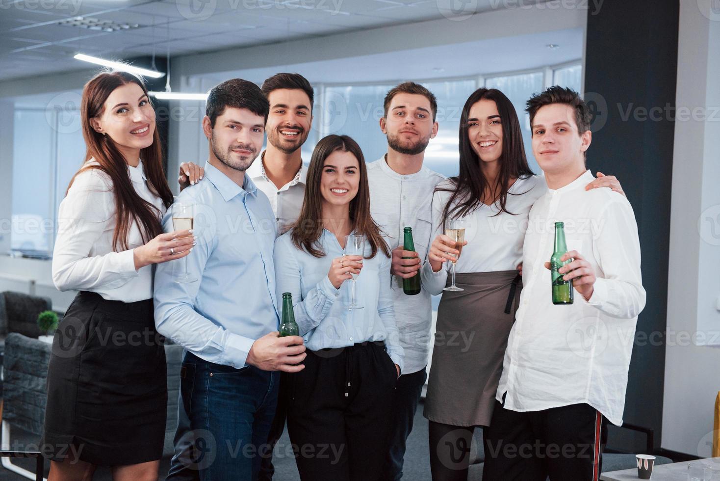 ha det bra. foto av ungt team i klassiska kläder som håller drinkar i det moderna bra upplysta kontoret