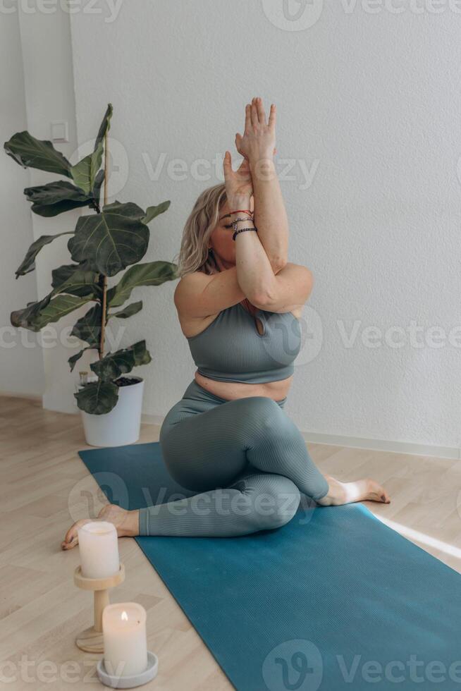 en 50-åring kvinna gör yoga på Hem foto