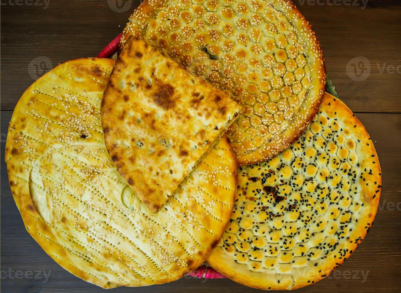 sortiment av bröd tandoori paratha, aloo naan, särskild roghni, kalonji naan, eras i korg isolerat på tabell topp se av Indien och pakistansk mat foto