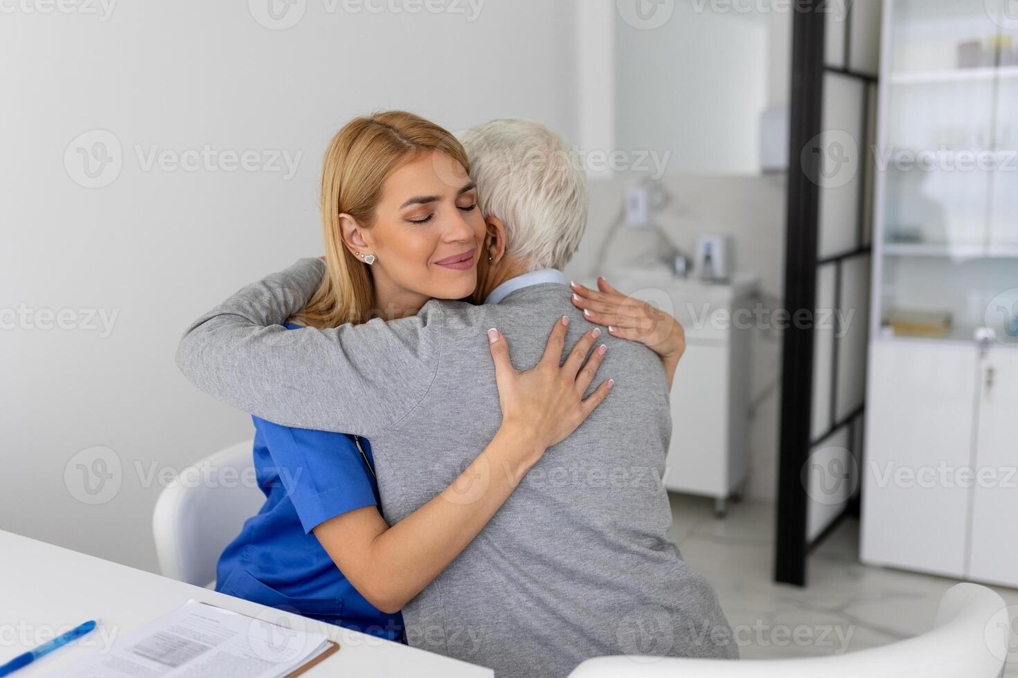 de äldre kvinna åtnjuter ett omfamning från henne favorit sjukvård läkare. medicinsk vård, ung kvinna läkare kramas patient. empati begrepp. äldre kvinna kramas vårdgivare foto