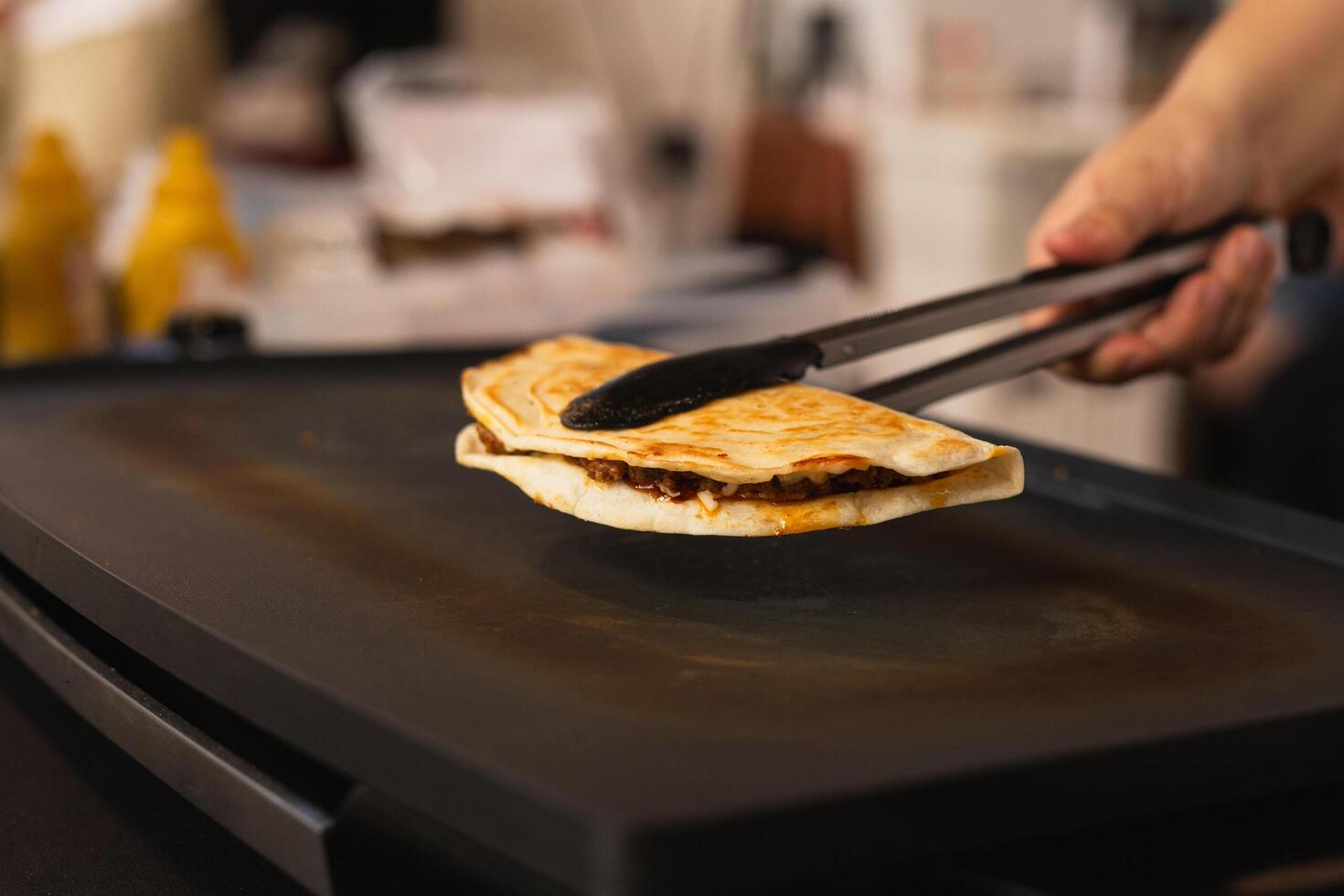 kock framställning färsk quesadilla på svart grill på lokal- mat marknadsföra. foto