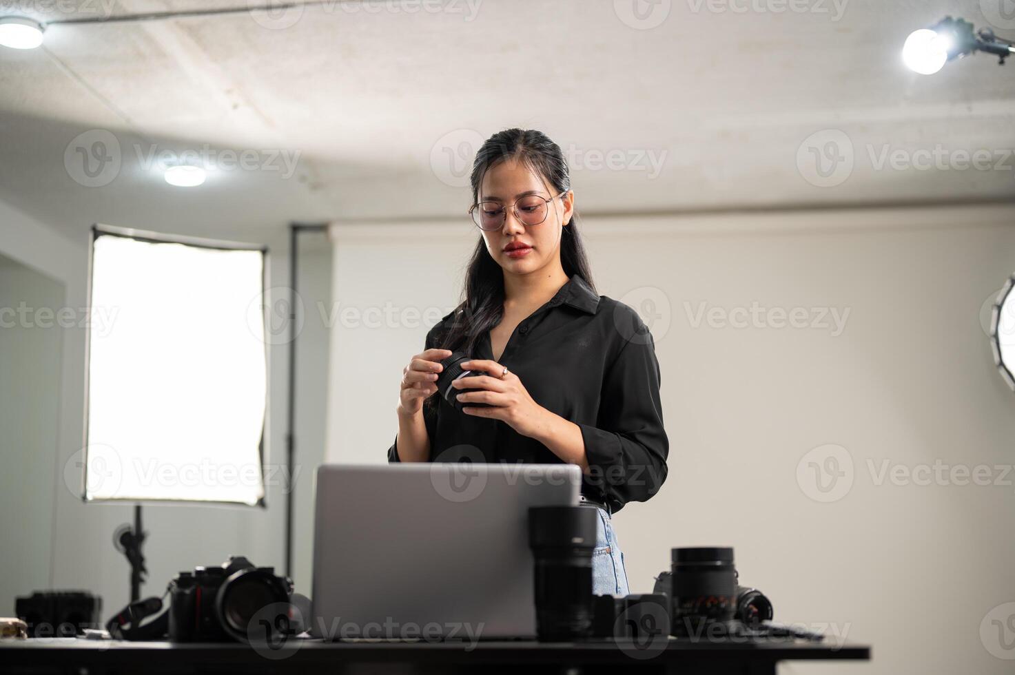 en kvinna fotograf är framställning henne kamerans lins för en fotografering, arbetssätt i en studio. foto