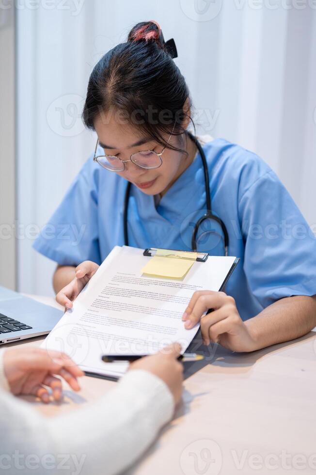 en läkare förklara en medicinsk försäkring krav dokumentera till en patient under en möte i de kontor. foto